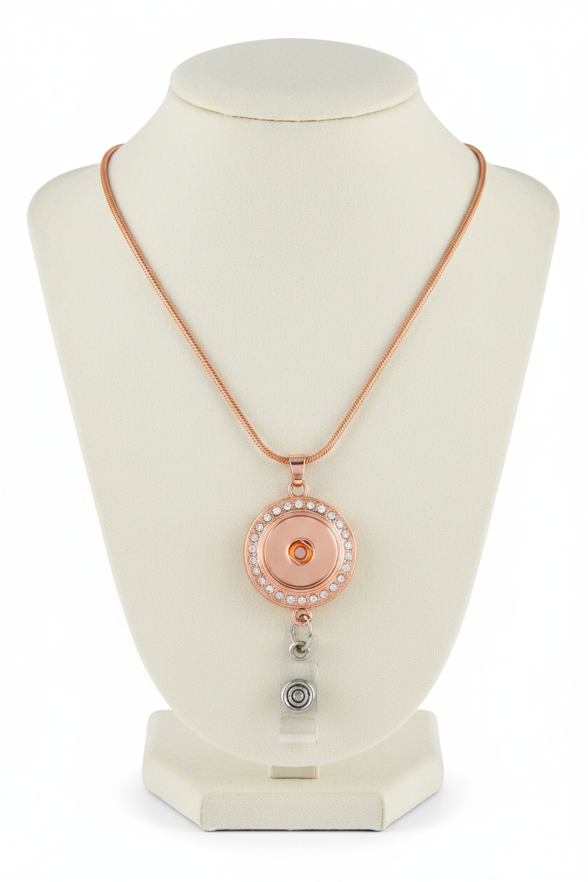 Rose gold lariat necklace with a circular pendant encrusted with clear rhinestones, featuring a silver-toned metal ring and a clear teardrop-shaped crystal drop charm, shown on a white background.