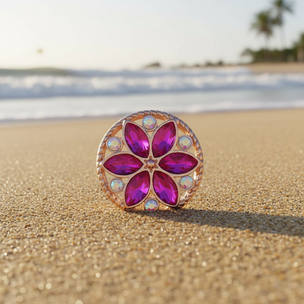A round rose gold snap button featuring a five-petal flower design with faceted magenta-purple marquise stones in the center and small iridescent round crystals around the border, set against a plain white background.