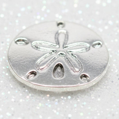 A round silver-toned metal charm or bead featuring an embossed starfish design. Locket Charm