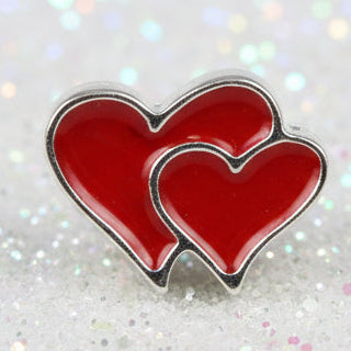 A red enamel charm shaped like two overlapping hearts outlined in silver-tone metal, shown on a black background.