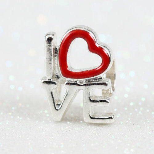 A silver-toned charm spelling 'LOVE' with a red heart outline over the letter O, shown on a dark background.
