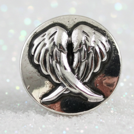 A round silver-toned metal snap button featuring an engraved winged figure design