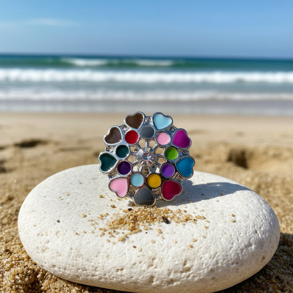 A silver-toned flower-shaped snap button featuring multiple colorful heart-shaped enamel inserts in shades of pink, blue, green, yellow, purple, red, and gray