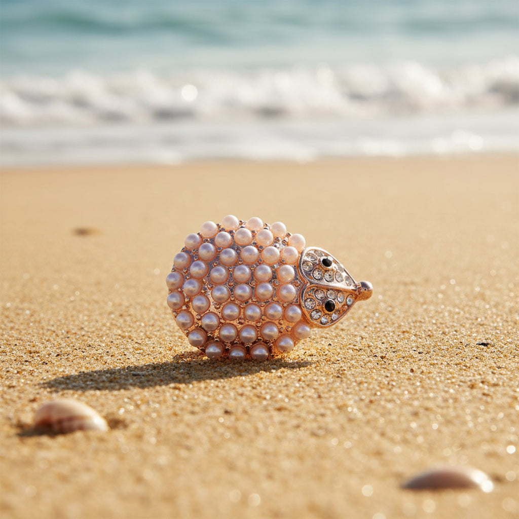 A rose gold owl-shaped snap button featuring a textured body covered in white faux pearls and a head embellished with clear rhinestones and small black enamel details, shown on a plain white background.