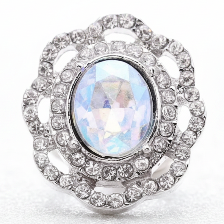 A silver-toned snap button with a large iridescent oval center stone and surrounding clear stones