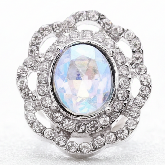 A silver-toned snap button with a large iridescent oval center stone and surrounding clear stones