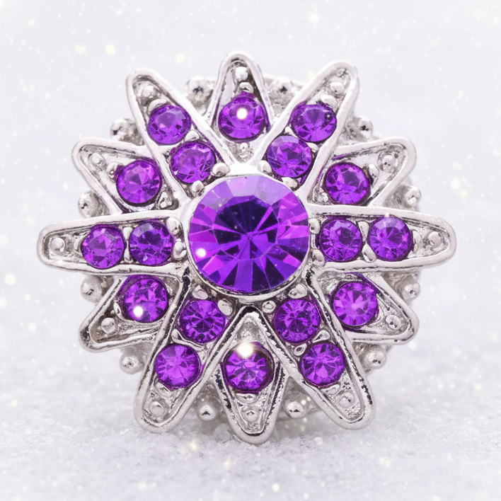 A silver-tone starburst ring featuring a large round purple crystal in the center, surrounded by multiple smaller purple and clear rhinestones on a white background.