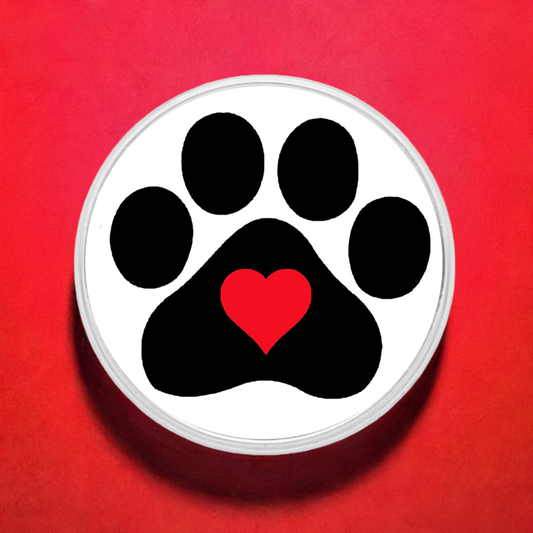 A statement snap with a paw print design in black and a red heart in the center, set against a solid red background.