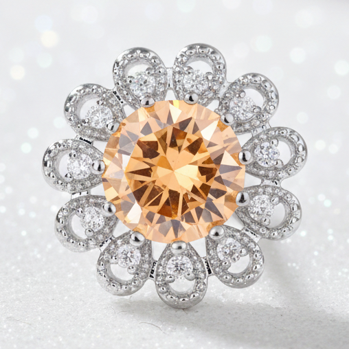 A floral-shaped silver snap button eaturing a large round faceted orange gemstone in the center, surrounded by eight smaller silver rings set with clear stones, on a plain white background.