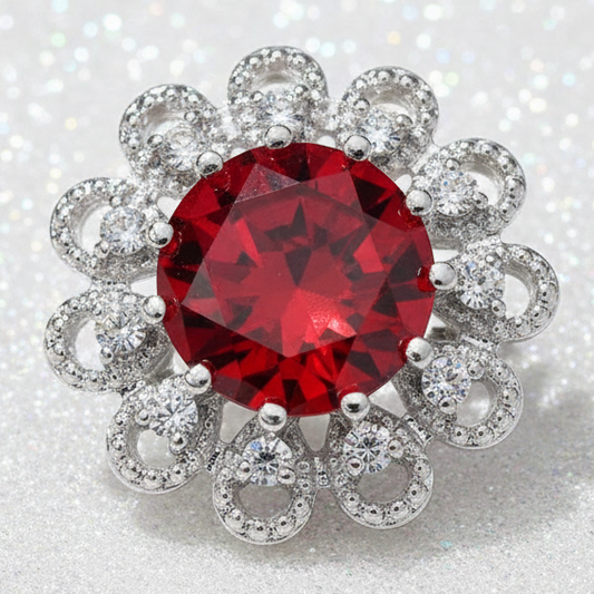 A floral-style red gemstone snap button featuring a large round red center stone surrounded by smaller clear stones in silver-toned settings, isolated on a white background.